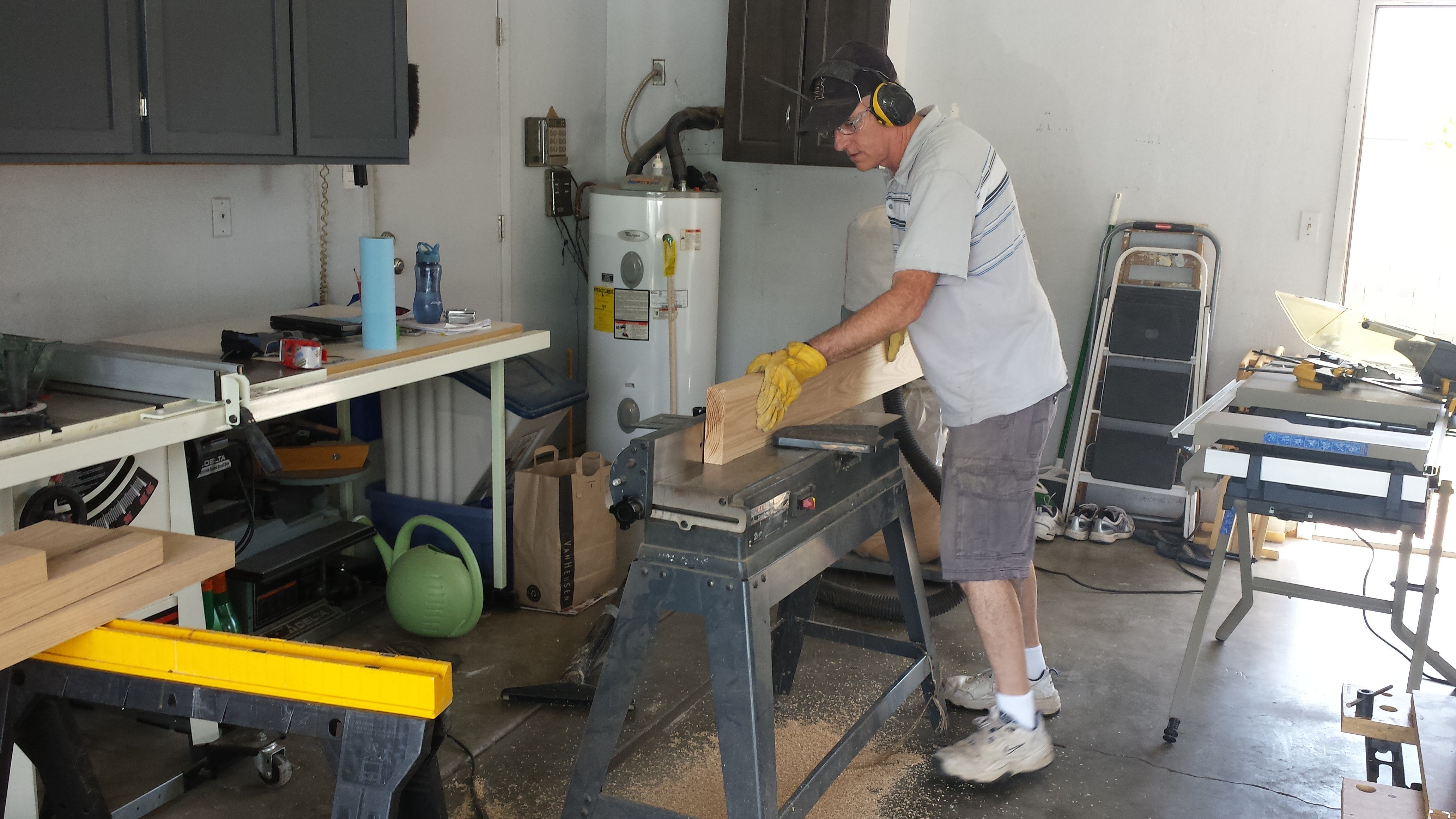 My dad using the jointer to square up the edges and make a nice flat surface for the legs of the furniture.