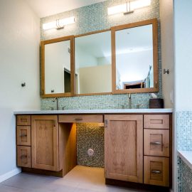 Chandler Spa Suite – Studio Em Interiors -The lighter wood cabinetry at the vanity helps to keep a bright, airy feeling in the space. The mirror has a medicine cabinet above each sink.