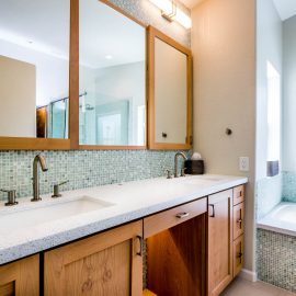 Chandler Spa Suite – Studio Em Interiors – The countertops have pieces of recycled glass inlaid in the tops, using the blue and green tones throughout.